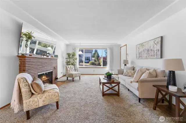 Beautiful, spacious living room with wood fireplace and large picture window