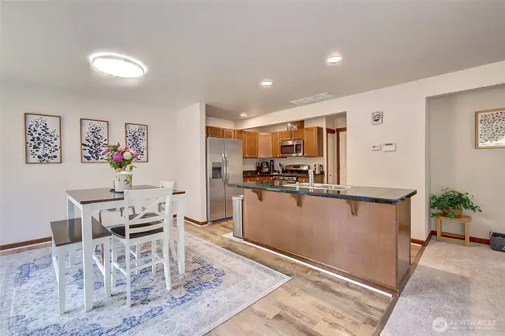Spacious kitchen and dining area with new luxury vinyl plank flooring that flows beautifully throughout the space. The open layout makes cooking, dining, and entertaining easy, and all-new lighting brightens every corner.