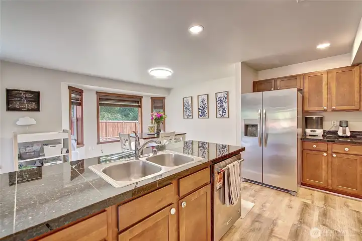 Well-laid-out kitchen with granite tile countertops, stainless steel appliances, and new LVP flooring that adds a fresh, modern touch. The open design makes it easy to cook, entertain, and stay connected with the dining and living areas.