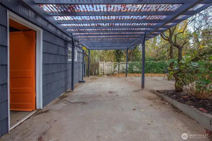 Covered garage porch area- great for bikes or add an outdoor heater and enjoy dry seating area in all weather