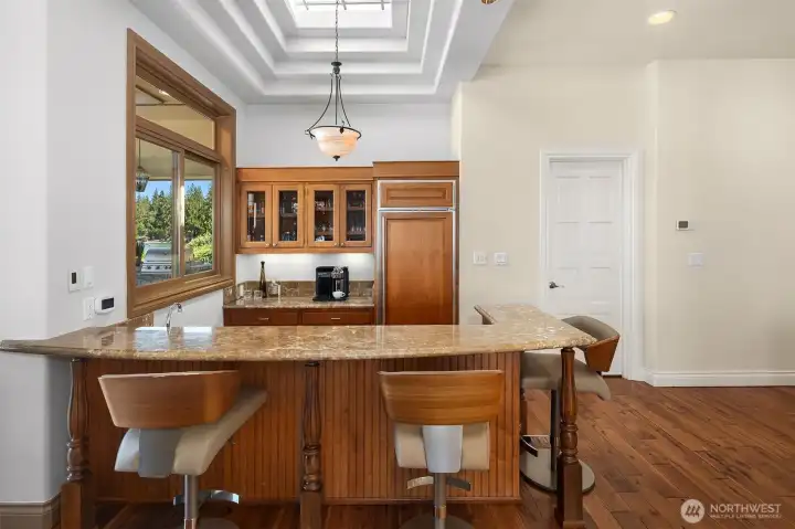 Wet bar w/fridge, sink, storage, seating, & skylight.