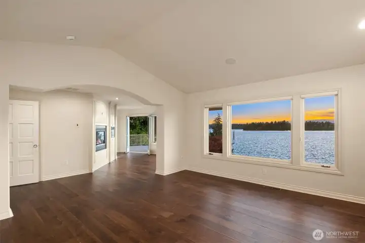 The grand staircase leads to the Large Primary Suite w/vaulted ceilings. Picturesque Lake Tapps views.