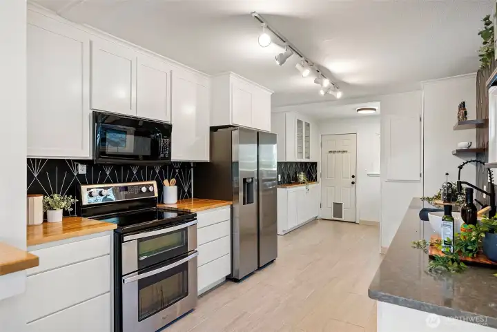 Kitchen equipped with a double oven and newer refrigerator.