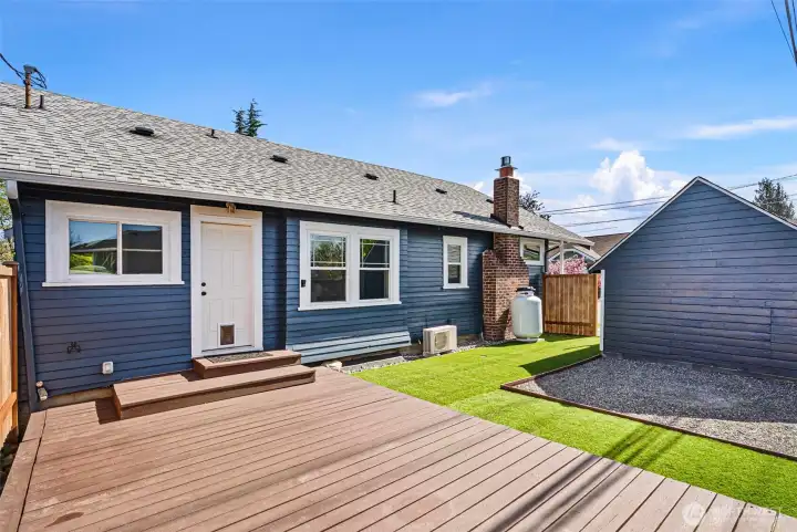 Private, fully fenced yard with artificial turf, a well maintained deck and appointed space for a fire pit.