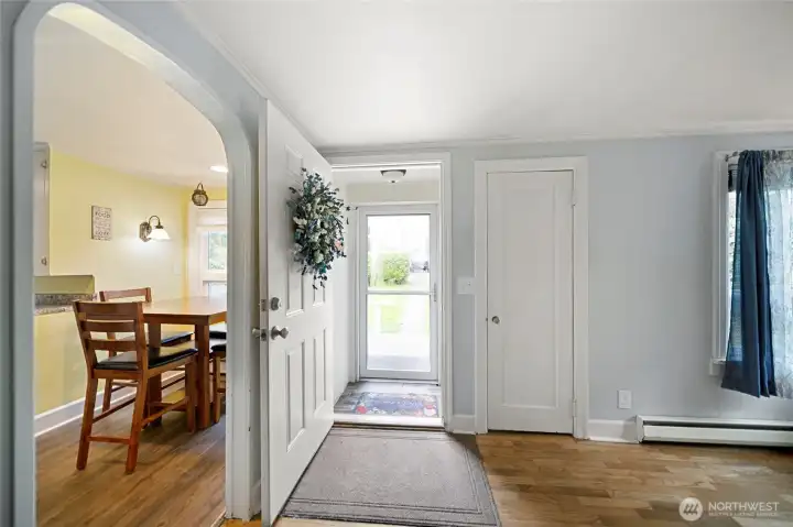 Entry to living room with hardwood floors and large windows.