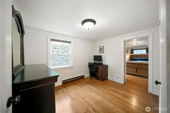 Second bedroom showing entry to the primary bedroom.