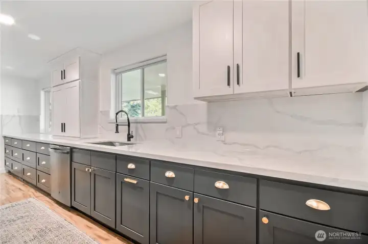 Elegant kitchen with quartz countertops, backsplash and trendy hardware.