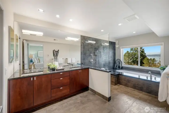 Private and relaxing, this spa-like bath includes double sinks, a glass-enclosed multi-head shower, a deep soaking tub, and a separate water closet designed for everyday comfort.