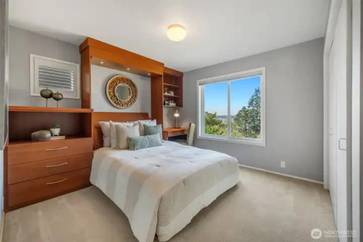 Located on the view side of the home, this secondary bedroom includes a Murphy bed and a custom closet, offering flexible functionality