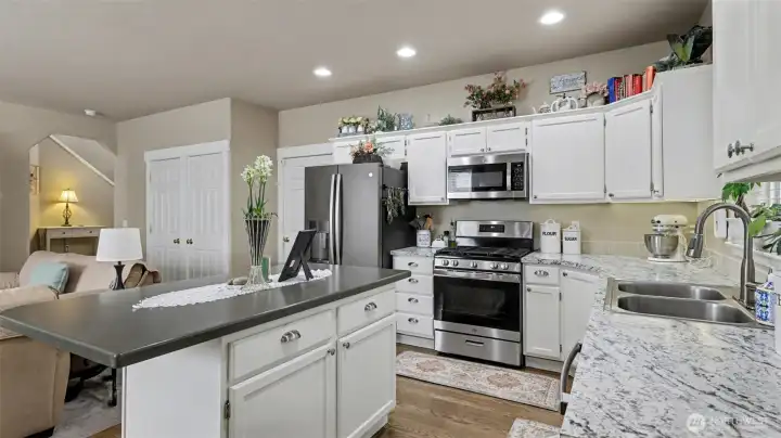 The kitchen has been thoughtfully upgraded with newer appliances, including a gas cooktop, elevated refrigerator, microwave with air fryer, and a spacious walk-in pantry.