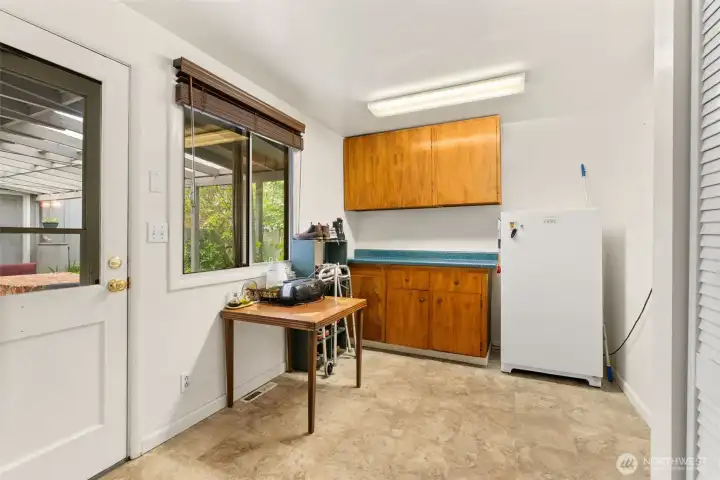 Functional mudroom/laundry area with additional storage, workspace potential, and convenient outdoor access.