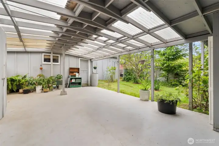Expansive covered outdoor area between the home and garage, ideal for entertaining, projects, or year-round enjoyment.