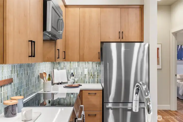 Full kitchen remodel in 2025 including: new countertops, reconfigured/enlarged counter, new glass backsplash, new Canyon Creek maple cabinets with soft close drawers and doors, black Silgranit sink, Fisher & Paykel refrigerator, Miele dishwasher, Bosch induction range