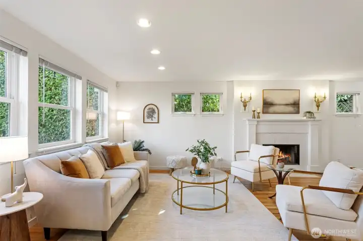 Living Room - Large extended room with plenty of light from windows all around, accented by a wood fireplace.
