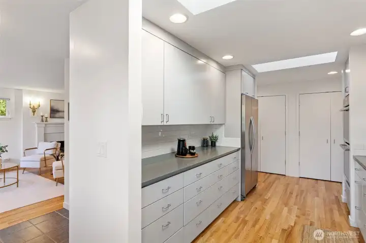 Great flow from the kitchen to the living spaces and showing the beautiful refinished flooring and ample pantry spaces.