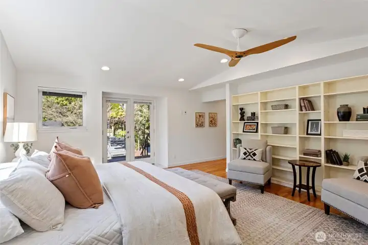 . Lots of shelving for books or displays, a custom light fixture, vaulted ceilings, plenty of windows with French doors opening to a private deck, leading down to the hot tub.