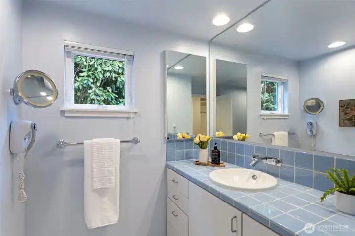 The ensuite mid century blue tiled bathroom on the main floor, one of two bathrooms in this floor.