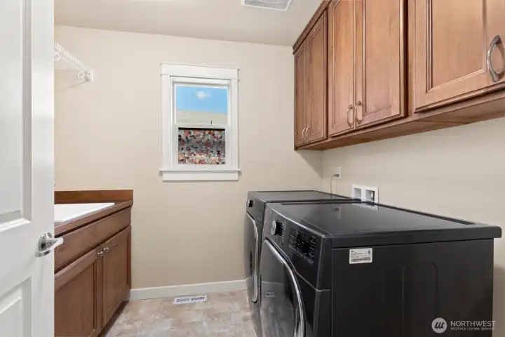 Upstairs laundry with extra cabinets and sink.