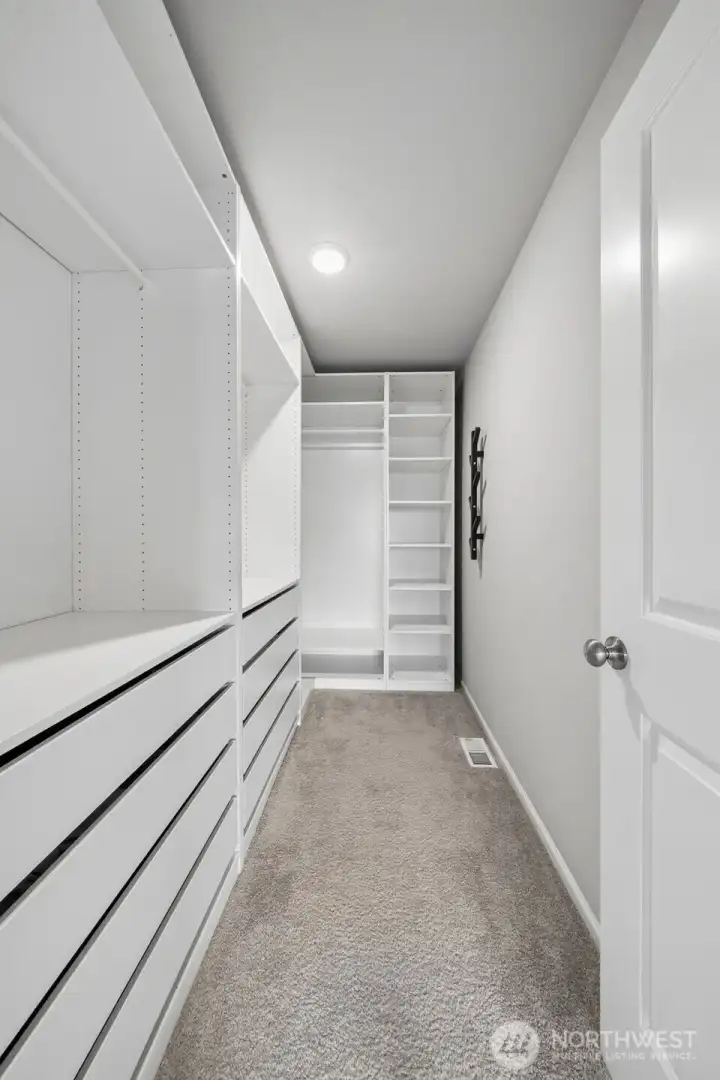 Primary walk in closet with custom closet system