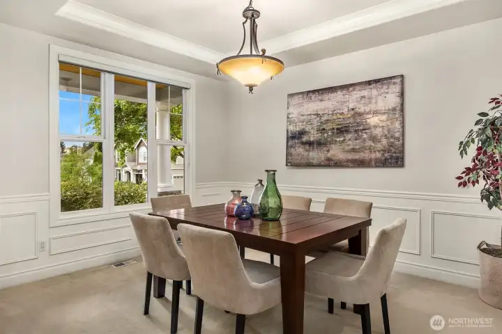 Beautiful architectural details, including tray ceilings and wainscoting, enhance the home’s charm, while expansive windows flood the space with natural light. Beautiful architectural details, including tray ceilings and wainscoting, enhance the home’s charm, while expansive windows flood the space with natural light.