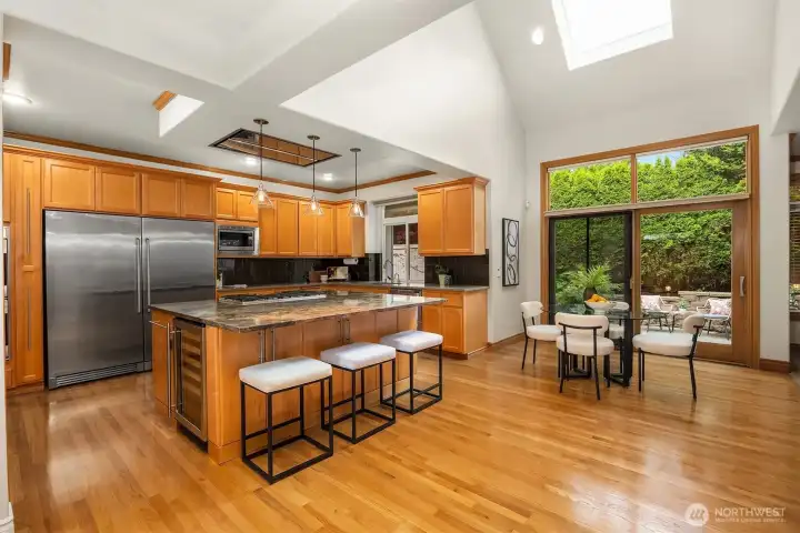 Light-filled chef’s kitchen with vaulted ceilings and skylight creates an inviting central gathering space. Light-filled chef’s kitchen with vaulted ceilings and skylight creates an inviting central gathering space.