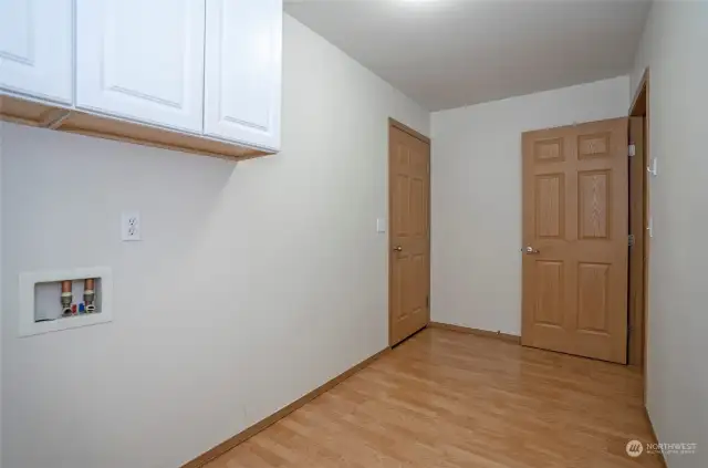 Utility room with additional storage cabinets and a door leading to the garage.