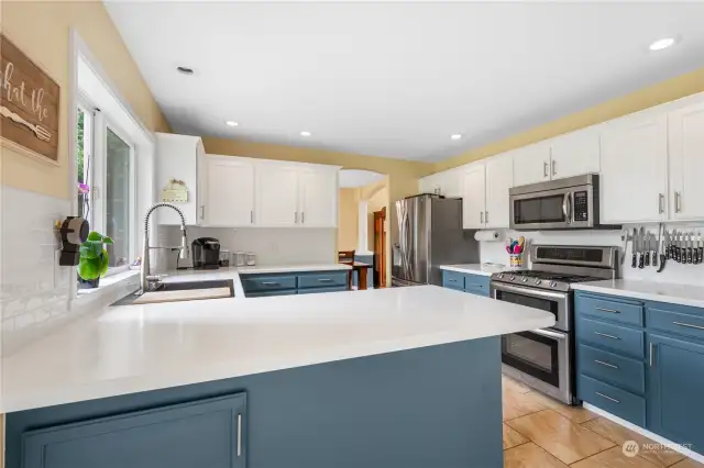 Kitchen with beautiful Corian counters, white tile backsplash, new faucet, stainless appliances and double ovens.