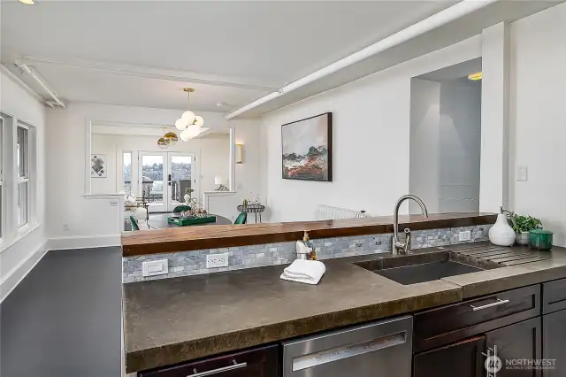 Kitchen features stainless steel appliances and custom concrete countertops.