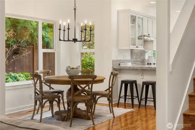 Looking from the bottom of the stairs toward the eat-in kitchen space and the kitchen. Great views out to the perennial gardens.