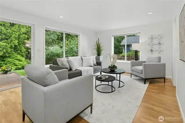 Cozy family room with lots of widows to enjoy the outdoor views as well as allowing for lots of natural light to enter this space and with more beautiful hardwood flooring.