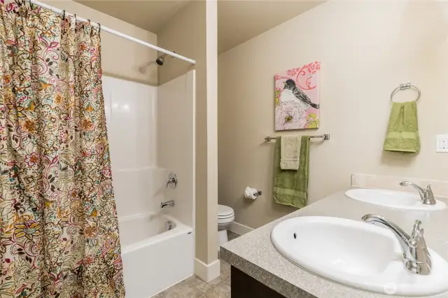 Full hall bathroom with linen closet & dual sinks