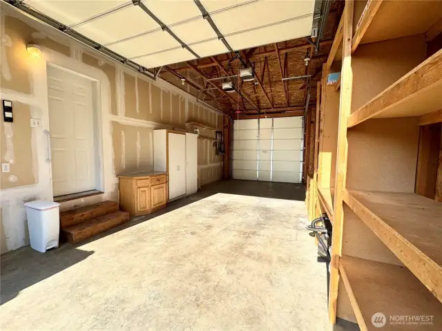 Garage has lots of built in storage. Garage door at both ends.
