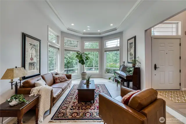 Sun drenched formal living room with coved ceiling, crown molding and hardwood floors.