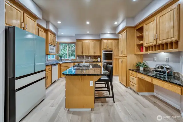 Kitchen with warm wood cabinets, granite tops and designer tile backsplash.