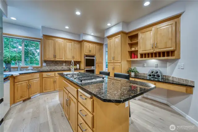Kitchen offering a double oven, pantry cabinets, deck area and decorative shelving.
