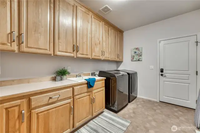 Fabulous laundry room with so much space and storage. Door leads to garage.