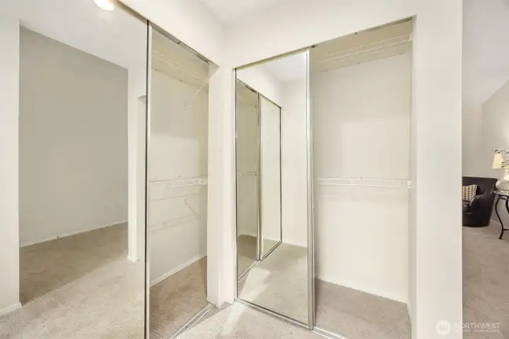 Primary corner closet with mirror doors - nice shoes!