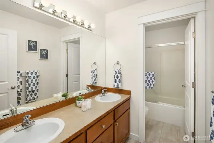 The family bath has dual vanities, nicely separated from the shower and water closet for more convenience. Also updated with new luxury vinyl plank flooring