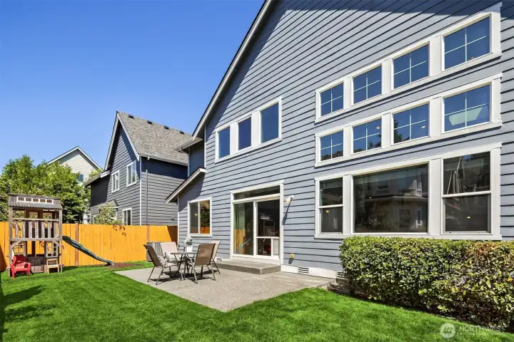 Perfectly sized backyard with just enough grass to feel soft beneath your feet and a space to play, but not too much to maintain