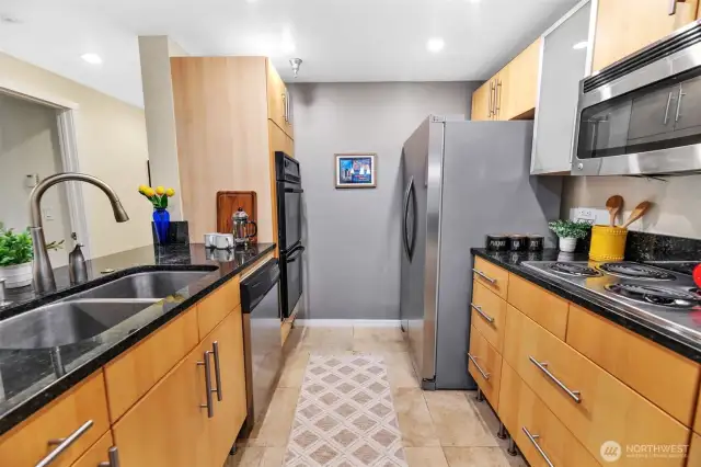 The kitchen has been updated with modern cabinetry, granite counter tops, and tile flooring.