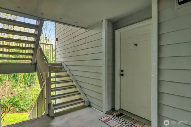 This condo has an open entrance. This unit is a corner unit and is only a few steps down from the entrance in the front. This view shows the door with the stairs looking towards the back towards the greenbelt. It's really lovely.