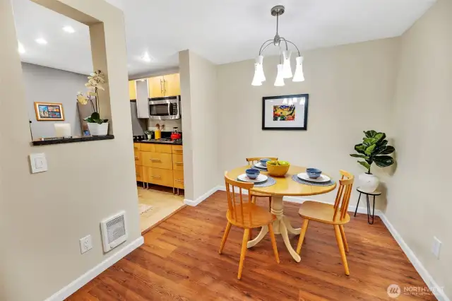 The dining room has a cool modern light fixture. This home has fresh paint and new LVP (luxury vinyl plank) flooring.
