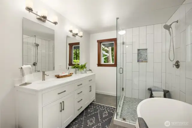 Double sink vanity, tiled shower.