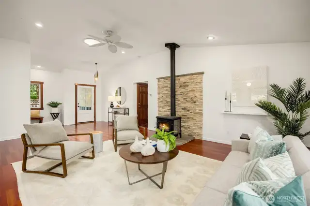 View across the living room/great room to the foyer. The wood burning stove will heat the entire home and has a beautiful stone backing.
