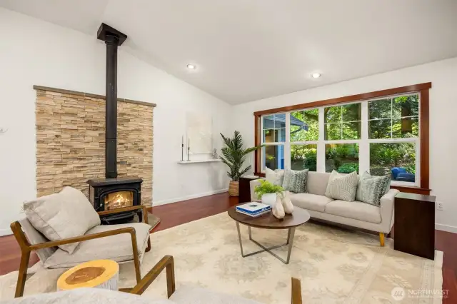 Tall windows with vertical grain trim. View across the back deck to the gardens, fire pit and lawn.
