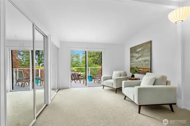 Double closets and a view of the sitting area and attached deck.
