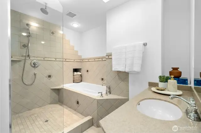 Primary bathroom with soaking tub, glass shower, and vanity.