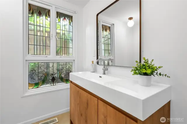 Second main floor bathroom with a lovely stained glass window, new vanity, sink, mirror and light fixtures.
