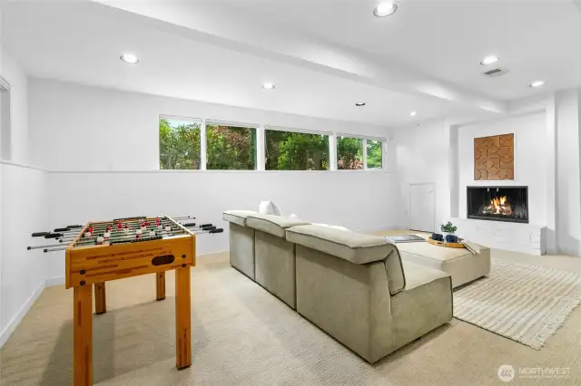 Large rec room with fireplace and space to play, relax, and enjoy movie nights.