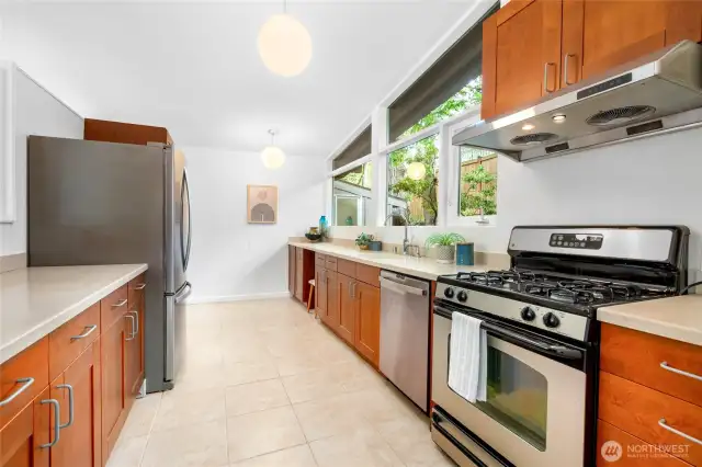 Open kitchen with gas range, expansive counterspace, abundant cabinets and windows that overlook the backyard.